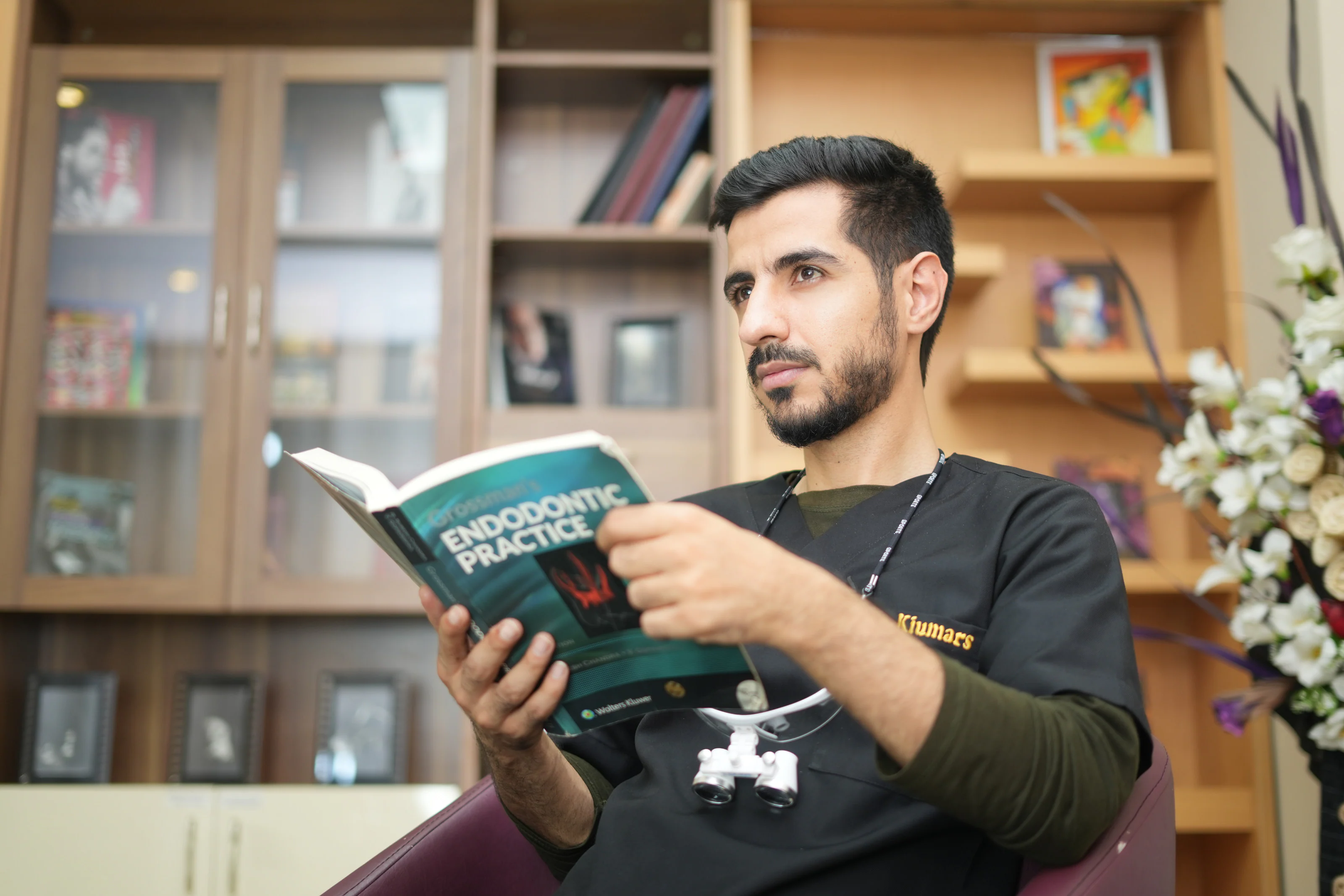 Dr. Arash Kiumars reading an endodontic practice textbook