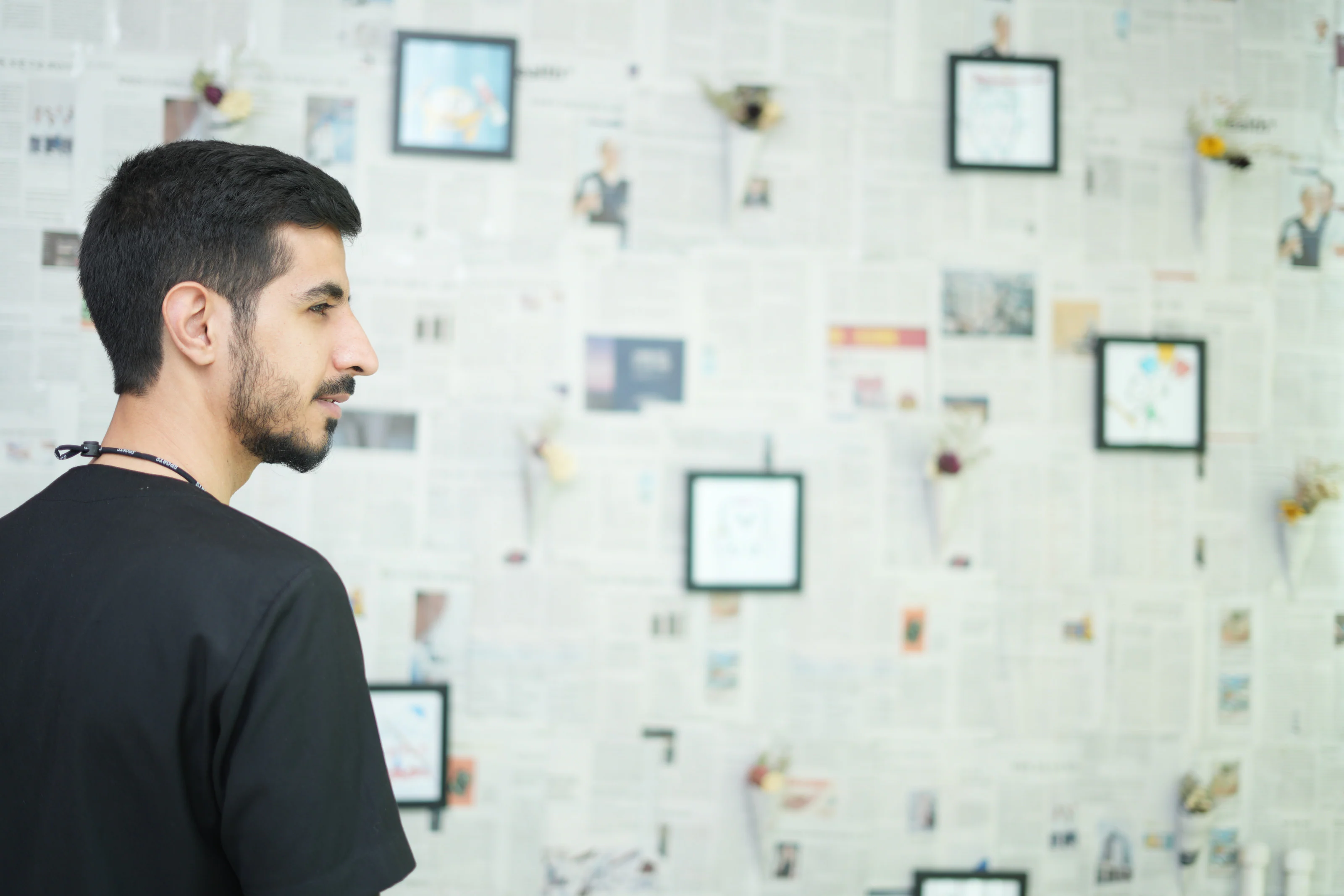 Profile of Dr. Arash Kiumars beside a gallery wall