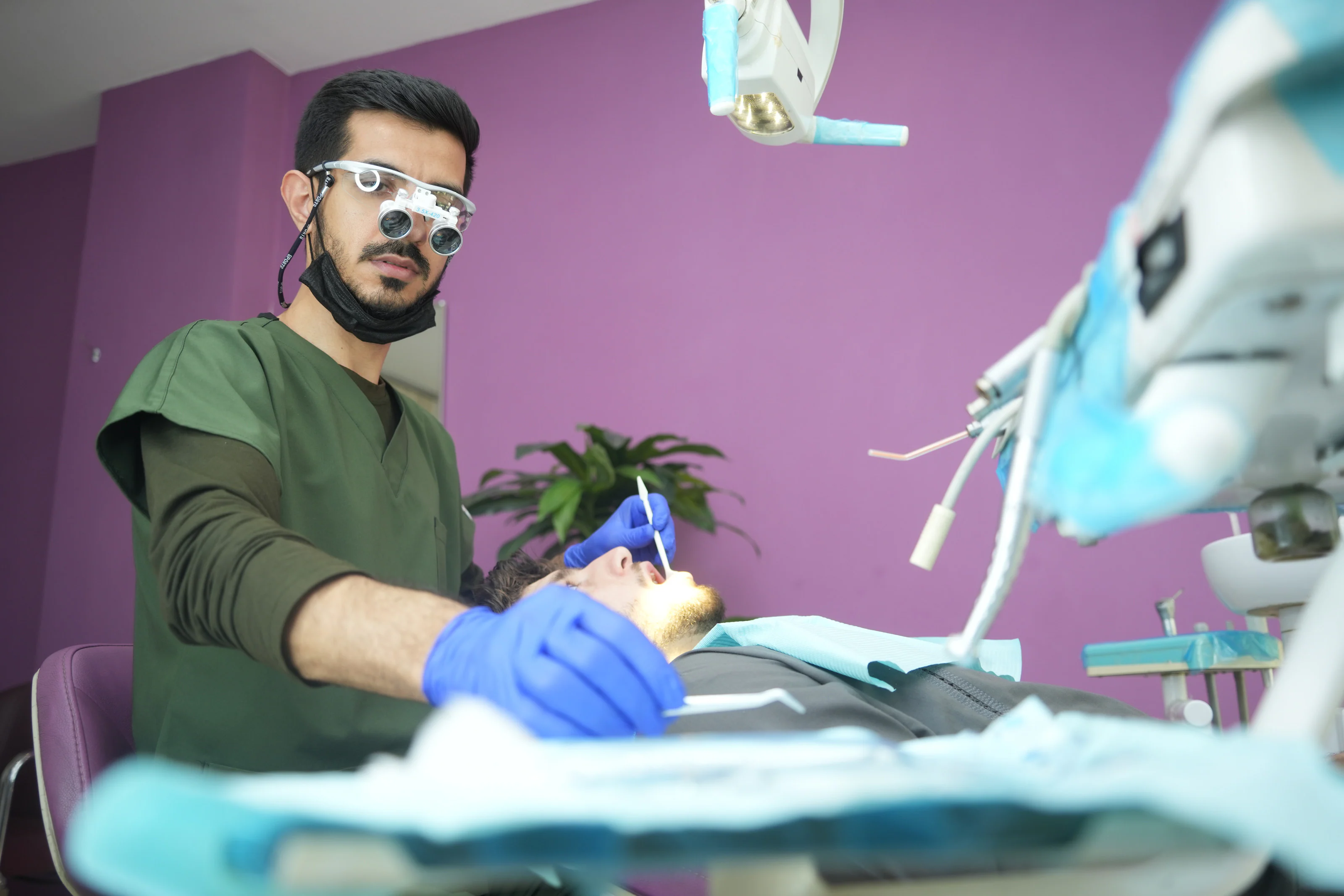 Dr. Arash Kiumars preparing instruments beside the dental chair
