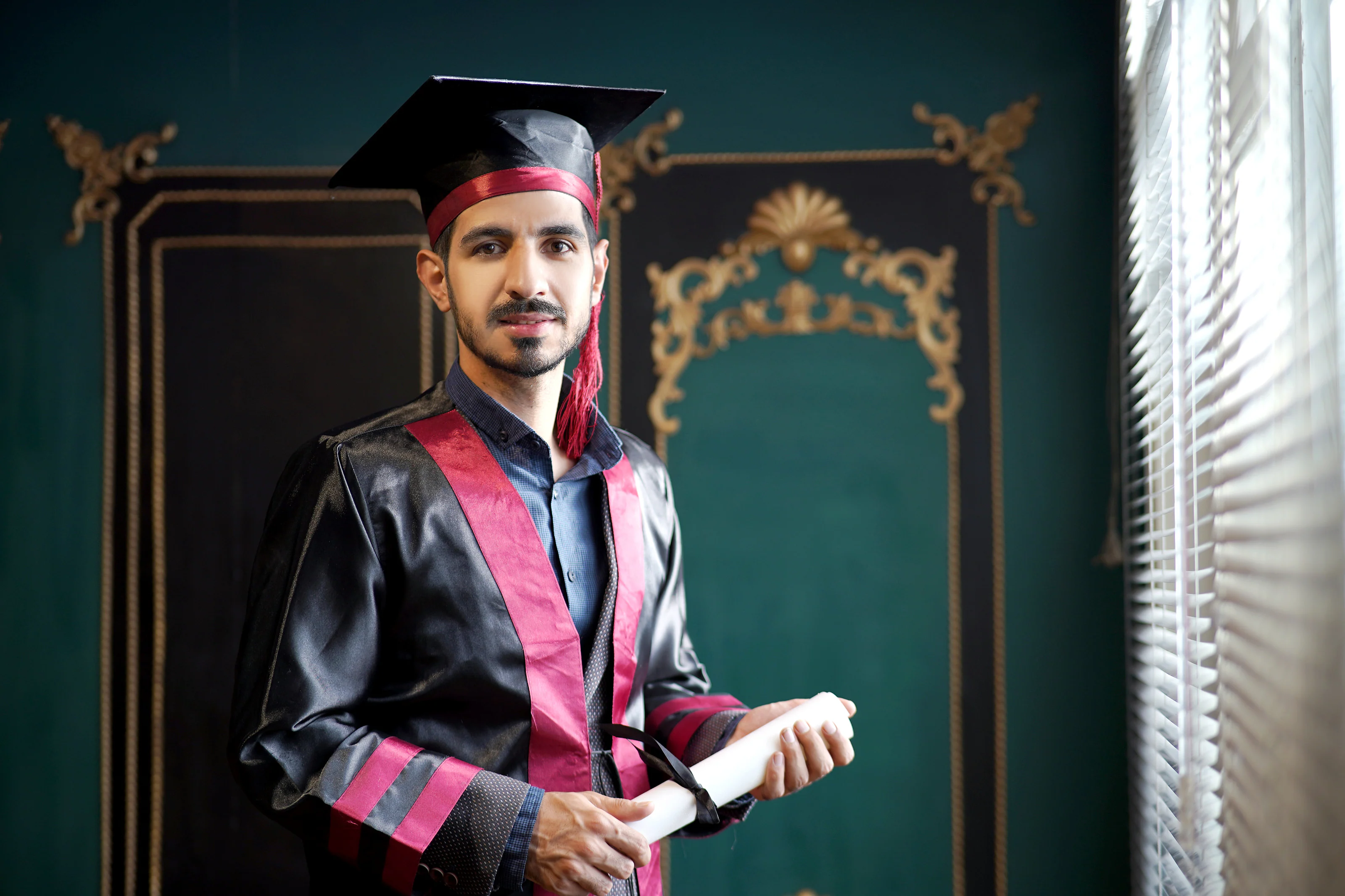 Dr. Arash Kiumars in graduation attire in a studio