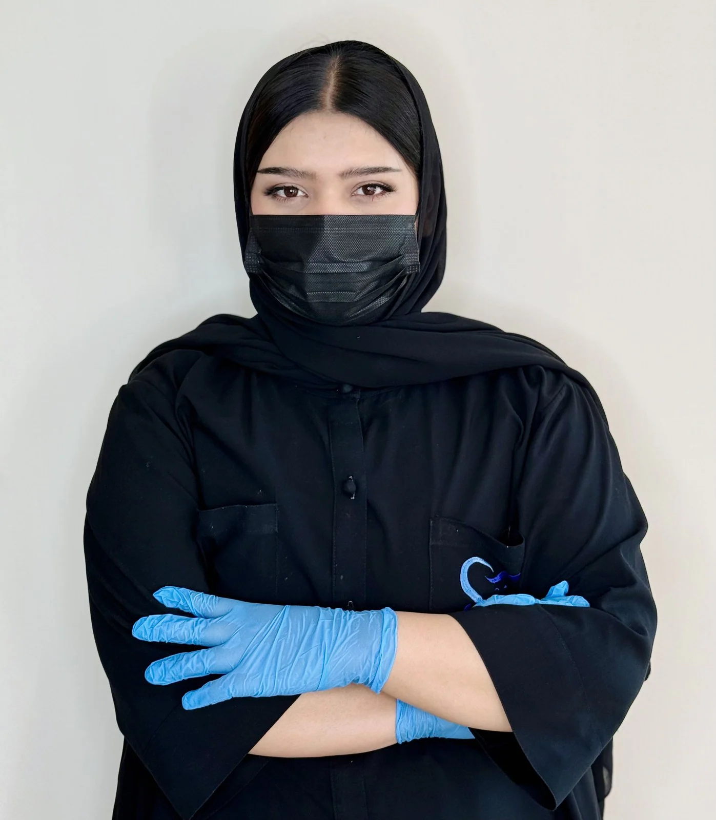 Tarina Mohammadi, dental assistant at City Smile Dental Clinic, in black scrubs, a face mask and blue gloves