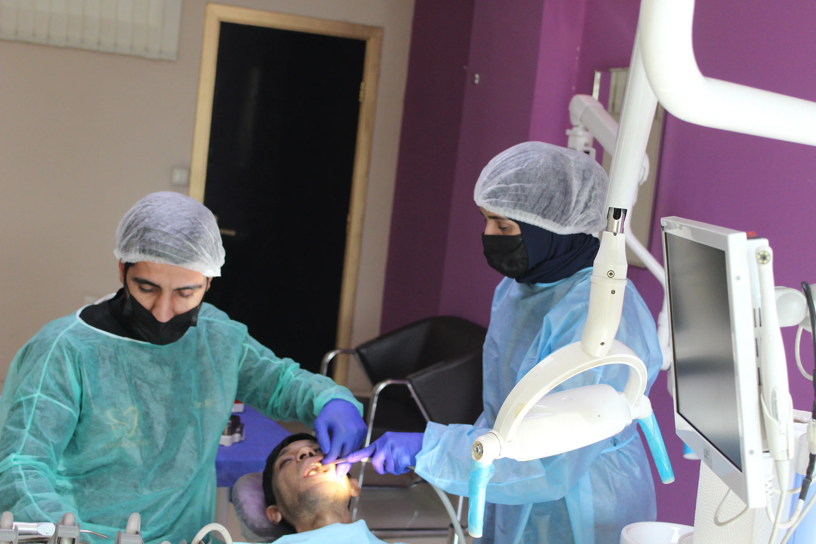 Dr. Arash Kiumars and an assistant treating a patient