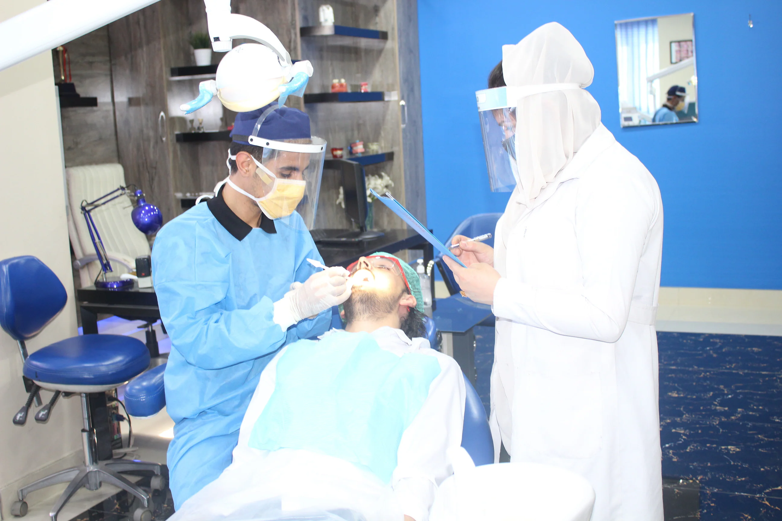 Dental team in protective equipment treating a patient